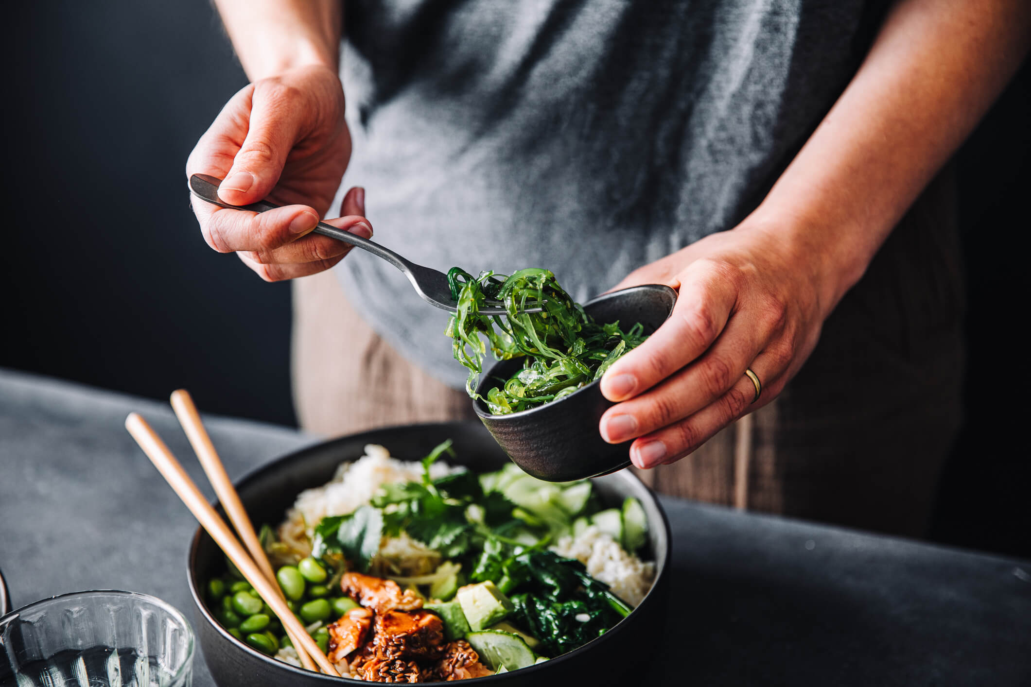 Man making a healthy salad bowl with seaweed salad to promote weight loss using weight loss injections.